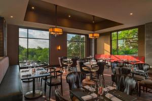 a restaurant with tables and chairs and large windows at Sheraton Austin Georgetown Hotel & Conference Center in Georgetown