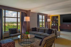 a living room with a couch and chairs and a tv at Sheraton Austin Georgetown Hotel & Conference Center in Georgetown