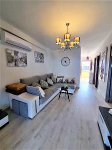a living room with a couch and a chandelier at Cabo Cervera primera linea apartamento de lujo in Torrevieja