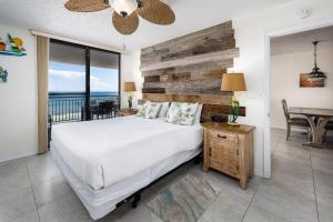 Un dormitorio con una cama blanca y una mesa con una mesa. en Nautilus 1503 - Gulf Front 2 Bedroom 5th Floor en Fort Walton Beach