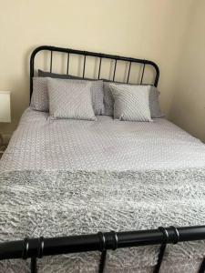 a bed with a black frame and pillows on it at 1 bedroom flat sleeps 4 in Abingdon Oxfordshire in Abingdon