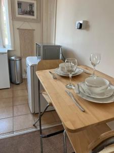 a wooden table with plates and wine glasses on it at 1 bedroom flat sleeps 4 in Abingdon Oxfordshire in Abingdon