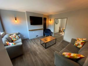 a living room with two couches and a television at 10 Tarleton Avenue, Woodhall Spa in Woodhall Spa