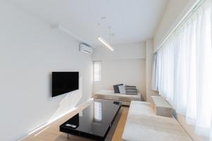 a white living room with a couch and a tv at MARSOL C,S,Beach hotel - Vacation STAY 51621v in Chigasaki