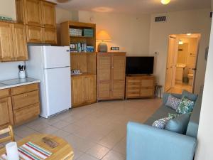 a kitchen with a refrigerator and a couch and a table at Caribbean Resort 501A - Link To The Beach in Navarre