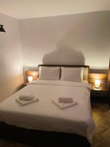 a bedroom with a bed with two towels on it at Pensiune Restaurant Indus in Ocna Sibiului