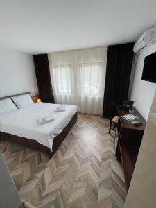 Habitación de hotel con cama y escritorio en Pensiune Restaurant Indus, en Ocna Sibiului