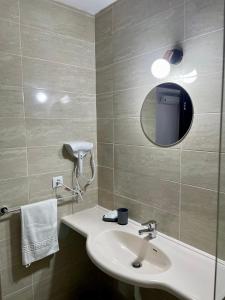 a bathroom with a sink and a mirror at Pensiune Restaurant Indus in Ocna Sibiului