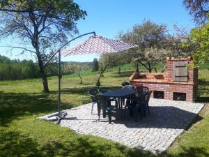een patio met een tafel en stoelen en een open haard bij Dom na Warmii 