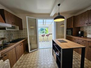 a kitchen with a counter and a glass door to a patio at chez Effat et marie T A C 2 in Noyers-sur-Cher