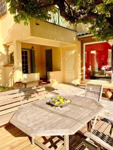 einen Holztisch mit einer Obstschale auf einer Terrasse in der Unterkunft Villa Belle Vue in Saint-Paul-de-Vence