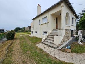 a white house with a statue in front of it at chez Effat et marie T A C 2 in Noyers-sur-Cher