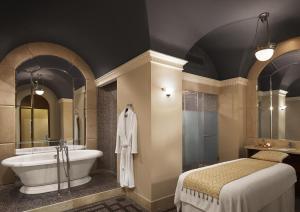 a bathroom with a tub and a bed and a sink at Umaid Bhawan Palace Jodhpur in Jodhpur