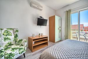 a bedroom with a bed and a tv and a chair at Apartments Irena in Hvar