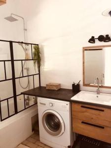 a bathroom with a washing machine and a sink at Maison Bois Jolan Sainte Anne in Sainte-Anne