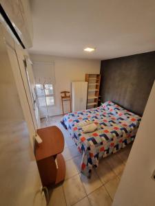 een slaapkamer met een bed en een stoel erin bij Depto en Cordoba para 4 personas in Cordoba