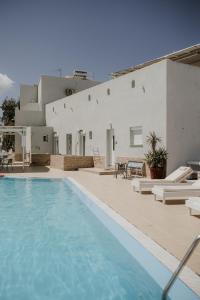 ein großer Pool neben einem weißen Gebäude in der Unterkunft Hotel Thirasia in Fira
