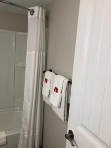 a bathroom with a white shower curtain and towels at Canadas Best Value Inn & Suites-Charlottetown in Charlottetown