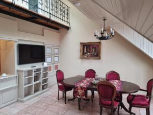 una sala da pranzo con tavolo, sedie e TV di DONATICOEUR Bellevue a Budapest