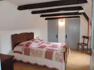 a bedroom with a bed with a red and yellow quilt at Charmante maison de campagne in Chasteaux