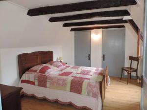 - une chambre avec un lit doté d'une couette rouge et jaune dans l'établissement Charmante maison de campagne, à Chasteaux