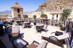 Boutique Hotel Sierra de Alicante في بوسوت: فناء به طاولات وكراسي على شرفة