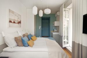een slaapkamer met een groot wit bed met blauwe kussens bij Sanhaus Apartments - Apartamenty Oslo z klimatyzacją in Sopot