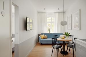 een woonkamer met een blauwe bank en een tafel bij Sanhaus Apartments - Apartamenty Oslo z klimatyzacją in Sopot