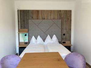 a bedroom with a bed with two purple chairs at Hotel Seerose Wolfgangsee in St. Wolfgang