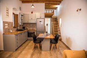 a kitchen with a table and chairs and a refrigerator at Mike's Guesthouse in Lakkíon