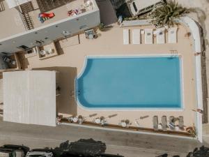 vue aérienne d'une piscine dans un bâtiment dans l'établissement Hotel Thirasia, à Fira