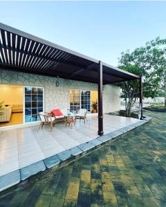 einen Pavillon mit einem Tisch und Stühlen auf einer Terrasse in der Unterkunft Luxury Farm Stay 50 in Badīyah