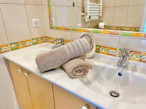 W łazience znajduje się umywalka i ręcznik. w obiekcie L’appartement du Fayé avec jacuzzi privé w mieście Étueffont-Bas