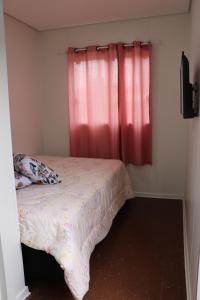 Un dormitorio con una cama y una ventana roja. en Canela Container, en Canela