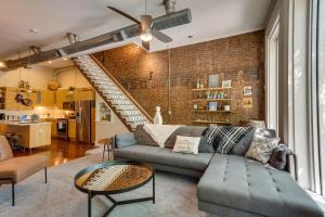 a living room with a couch and a brick wall at Kentucky Bourbon Loft about Downtown Louisville in Louisville
