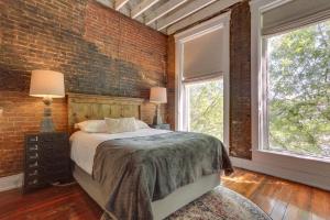 ein Schlafzimmer mit einem Bett und einer Ziegelwand in der Unterkunft Kentucky Bourbon Loft about Downtown Louisville in Louisville