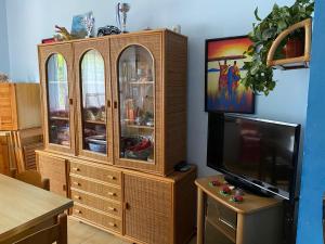 a wooden cabinet with a tv in a room at Casa Sole e Mare in Catania