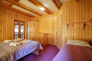 a bedroom with a bed and a wooden wall at Luxury Love Chalet in Mrkopalj