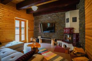 a living room with a couch and a stone fireplace at Luxury Love Chalet in Mrkopalj
