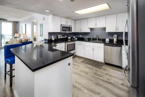 eine Küche mit weißen Schränken und einer schwarzen Arbeitsplatte in der Unterkunft Nautilus 1601 - Gulf Front 2 Bedroom - 6th Floor - Huge Wraparound Balcony in Fort Walton Beach