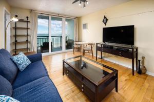 沃爾頓堡灘的住宿－Nautilus 1505 - Gulf Front 1 Bedroom - 5th Floor，客厅配有蓝色的沙发和平面电视。