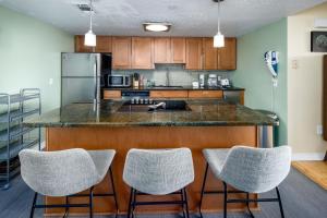 uma cozinha com um balcão com três bancos em Nautilus 1505 - Gulf Front 1 Bedroom - 5th Floor em Fort Walton Beach