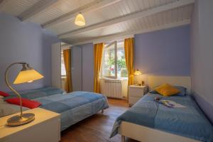 two beds in a room with blue walls at Casa del Sole in Colico