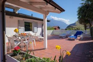 eine Terrasse mit einem Tisch, Stühlen und Bergen in der Unterkunft Casa del Sole in Colico