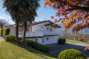 a large white house with trees in front of it at Casa del Sole in Colico