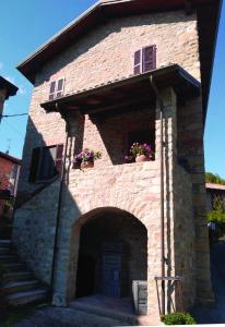 a brick building with two windows and a door at La Pomella in Ponte Nizza