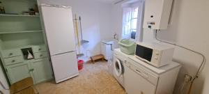 a kitchen with a refrigerator and a tv on a counter at Casa El Carril Vinuesa in Vinuesa +39 photos