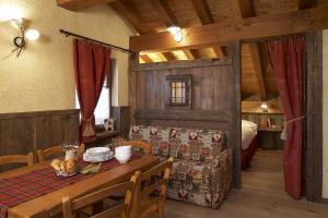 a dining room with a table and a bed at Residence Lo Peyo in Champoluc