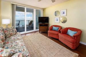 uma sala de estar com duas cadeiras vermelhas e uma televisão em Nautilus 1603 - Gulf Front 2 Bedroom - 6th Floor em Fort Walton Beach