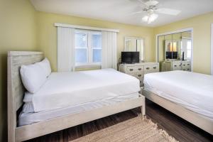 um quarto com duas camas e uma televisão em Nautilus 1603 - Gulf Front 2 Bedroom - 6th Floor em Fort Walton Beach